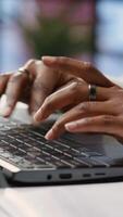 Vertical Freelancer in home office sitting at desk and typing on laptop keyboard. Close up of remote worker using electronic device to do customers relations job online, answering inquiries, camera B video