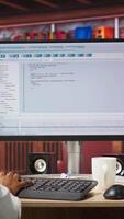 Vertical Software developer at PC coding, creating software, implementing algorithms. IT expert in home office working with code editor, building applications, optimizing performance, camera A panning shot video