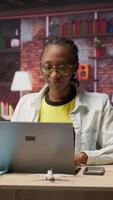 Vertical Worker at home starting job shift, opening laptop to analyze data at desk, compiling analytical reports. Remote employee beginning tasks, using notebook device, writing down information, camera B video