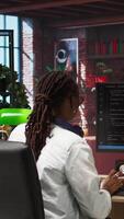 Vertical Admin uses computer for artificial intelligence computing simulation, waiting for code to finish compiling. African american woman works with AI deep neural networks at home, camera A video