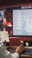 Vertical Programmer at computer desk coding, creating software, implementing algorithms. African american IT specialist in home office working with code editor, building applications, camera A video