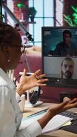Vertical Manager greeting employees during videocall from home, looking over paperwork, organizing job shifts. Supervisor doing remote teleconference meeting with staff members, checking documents, camera A video