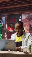 Vertical Freelancer in home office opening laptop, starting working on tasks. Remote employee using electronic device to do customers relations job online, answering inquiries, camera A video