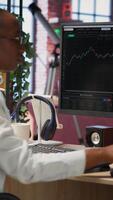 Vertical Frustrated day trader feeling upset, looking at PC screens showing falling stock prices, red charts and losses. Investor overwhelmed while looking at drop in stock exchange shares on monitor, camera B video