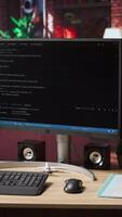 Vertical Programming language code editor software UI on computer display in home workspace, jib down shot. Lines of code displayed on PC monitor used to power digital software apps video