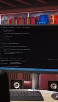 Vertical Code typed into PC entering commands and running script, panning shot of monitor on desk. Computer display in apartment used for fixing errors in application and implementing features video