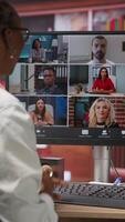 Vertical Employee greeting coworkers during videocall from home desk, organizing calendar appointments. Worker preparing for corporate event, doing remote videoconference meeting with colleagues, camera B video