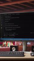 Vertical UI on computer monitor in home office with programming script being executed. Empty modern apartment room with coding application used by remote employee to write code, jib up shot video