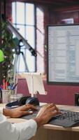 Vertical Programmer at computer desk coding, creating software, implementing algorithms. African american IT specialist in home office working with code editor, building applications, camera B video