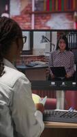 Vertical Remote employee calls manager remotely using internet videocall to ask for feedback on project progress. Teleworker at home requesting assistance from team leader in teleconference meeting, camera B video