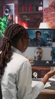 Vertical Manager greeting employees during videocall from home, looking over paperwork, organizing job shifts. Supervisor doing remote teleconference meeting with staff members, checking documents, camera B video