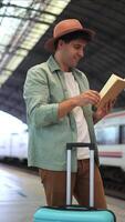 vertical patient traveler reading book with suitcase on platform waiting for delayed train video
