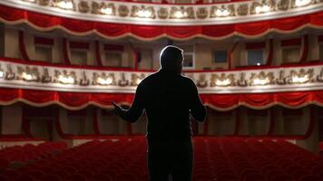 Kyiv, Ukraine, 29 May 2024 Announcer on a stage in theater. Bright round light on one person. Man in black suit performs to the auditorium. View from the back. video