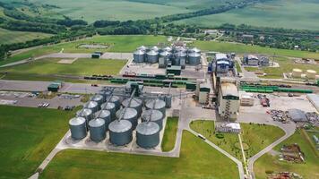 Large granary in field. A new built-in industrial grain elevator among nature. Silver containers for storing agricultural products. Aerial view. video