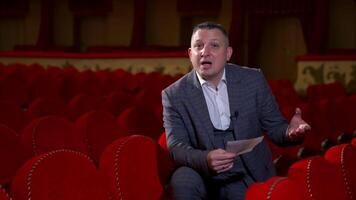 Kyiv, Ukraine, 29 May 2024 Man actor gives interview while sitting on red velvet chair in classic theater. Empty theter before evening performance. video