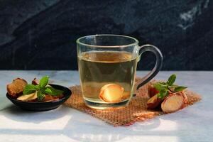 Ginger tea with mint in a glass on a Marble tile background photo