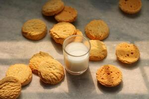 Milk in glass and cookies on the table photo