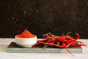 rojo caliente chile pimienta polvo en un blanco cuenco con rojo chile foto