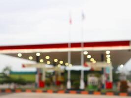 a blurry image of a gas station with a red and white sign photo