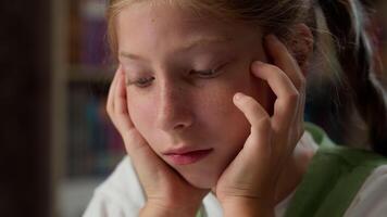 Close up sad face tired child school kid exhausted bored schoolgirl learner pupil lazy sleepy Caucasian little girl student doing hard difficult task reading homework exam indoors classroom education video