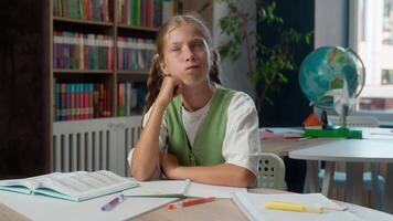 Thoughtful Caucasian pondering little girl school child kid schoolgirl learner student thinking solving difficult task exam test eureka raising finger finding solution answer idea in classroom library video
