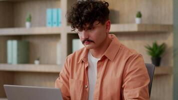Caucasian businessman designer male guy business man employee office manager freelancer at workplace company working laptop typing online computer studying programming at desk looking at camera smile video