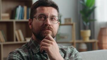 Portrait pensive thinking hesitate unsure think thoughtful confused puzzled Caucasian man male guy come up with idea finding answer creative solution insight smiling looking at camera at home indoors video