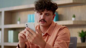 Caucasian guy business man entrepreneur businessman male office employee using mobile phone search data browsing internet gadget addiction smartphone typing message pay order shopping cellphone screen video