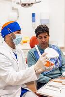Dentist showing anatomical model of teeth to patient explaining treatment photo