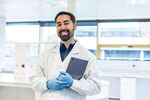 Scientist smiling and holding tablet in a bio laboratory photo