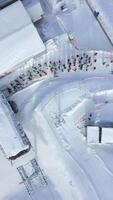 Aerial view of a queue of people waiting for a chairlift at a snowy ski slope video