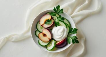 Plum and cucumber salad with yogurt dressing and parsley garnish. photo