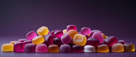 Vibrant assorted gummy candies arranged on a smooth purple backdrop for enticing confectionery visuals. photo