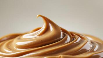 Close up of creamy smooth peanut butter texture with glossy sheen and rich golden brown color perfect for food and culinary backgrounds photo