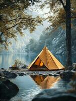A serene campsite by a lake with a reflective yellow tent and surrounding nature. photo
