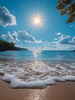 A serene beach scene with sun rays reflecting on water and gentle waves lapping at the shore. photo