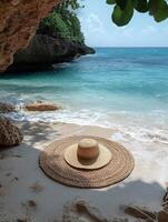 A serene beach scene featuring a straw hat on a round mat near gentle waves. photo