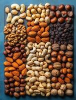 A colorful assortment of various nuts and dried fruits arranged neatly on a surface. photo