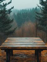 A wooden table in a misty forest, surrounded by trees and autumn foliage. photo