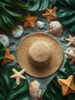 A flat lay of a straw hat, seashells, and starfish surrounded by tropical leaves. photo