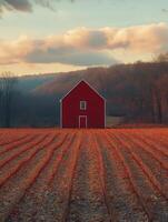 A serene landscape featuring a red barn amidst autumn fields and distant hills. photo