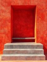 A vibrant red wall with a recessed area and steps leading up to it. photo