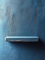 A simple blue wall with a small shelf, emphasizing minimalism and color. photo
