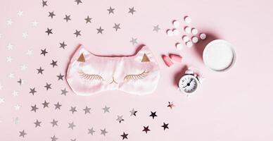 Concept good sleep, magnesium powder, sleep mask, alarm clock and earplugs on pink web banner photo