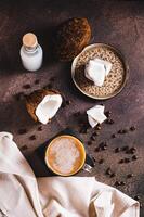 Cup of iced coconut coffee, coconut pulp and coffee beans on table top and vertical view photo