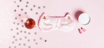 Concept good sleep, magnesium powder, sleep mask, cherry juice and earplugs on pink background photo