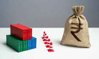 Shipping containers with goods and indian rupee money bag are separated by a barrier. Economic sanctions. Break a trade deal. Naval blockade. Logistics difficulties. photo