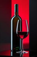 Still life of a wine bottle and a glass of red wine. The composition is made on a bright background with a gradient of rich red and black colors, which creates a dramatic and elegant atmosphere. photo