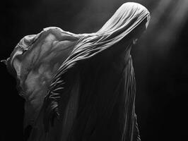 Ethereal figure cloaked in flowing fabric illuminated by soft light photo