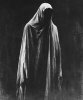 Mysterious figure draped in shadowy fabric stands in dimly lit space photo
